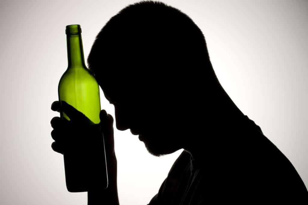 silhouette of man holding a wine bottle